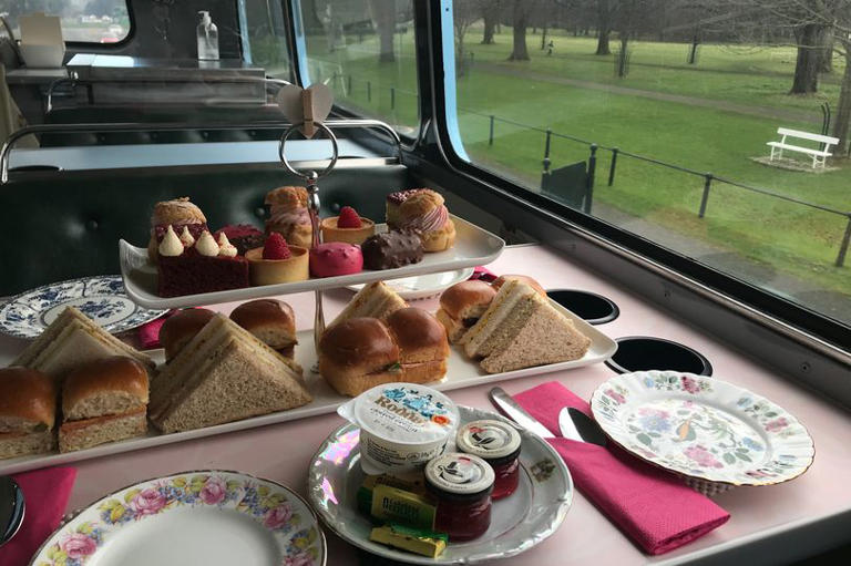 Sandwiches and cakes on white trays on a white table on a bus in Dublin's Phoenix Park