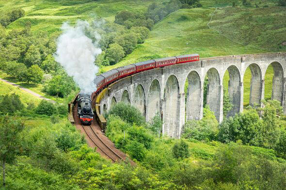 The Jacobite steam train on Glenfinnan viaduct in North West Highlands, Scotland, UK. The train and the bridge have been featured in the Harry Potter 