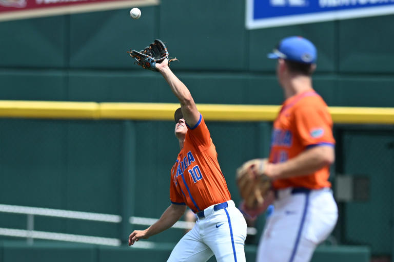 Jun 17, 2024; Omaha, NE, USA; Florida Gators shortstop Colby Shelton (10) catches a pop fly against the NC State Wolfpack during the second inning at Charles Schwab Field Omaha. Mandatory Credit: Steven Branscombe-USA TODAY Sports