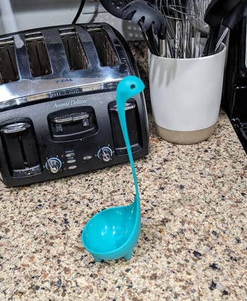 Nessie-shaped kitchen ladle standing upright