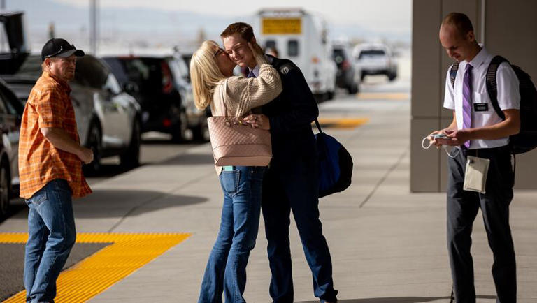 Rusty Dutson, left, watches as his wife, Margaret Dutson, bids farewell to their son, Elder Hayden Dutson, as he and Elder Jonathon Buhler, right, depart for missions for The Church of Jesus Christ of Latter-day Saints at Salt Lake City International Airport in Salt Lake City on Thursday, Nov. 18, 2021. The two missionaries are both bound for the church’s Missionary Training Center in Accra, Ghana.