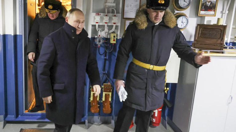 Russian President Vladimir Putin, left, visits the newest frigate "Admiral of the fleet Kasatonov" during a flag-raising ceremony on Monday for newly-built nuclear submarines