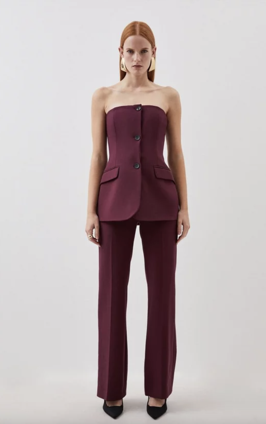 <p><strong>£159.20</strong></p><p><a href="https://www.karenmillen.com/compact-stretch-tailored-button-bodice-jumpsuit/BKK05804.html">Shop Now</a></p><p>Meet your new events staple. We love the strapless bandeau bodice with flared trousers combo. Not forgetting that gorgeous dark purple colour, dreamy! Glam it TF up with sparkly shoes and piles of jewellery for a wedding. </p>