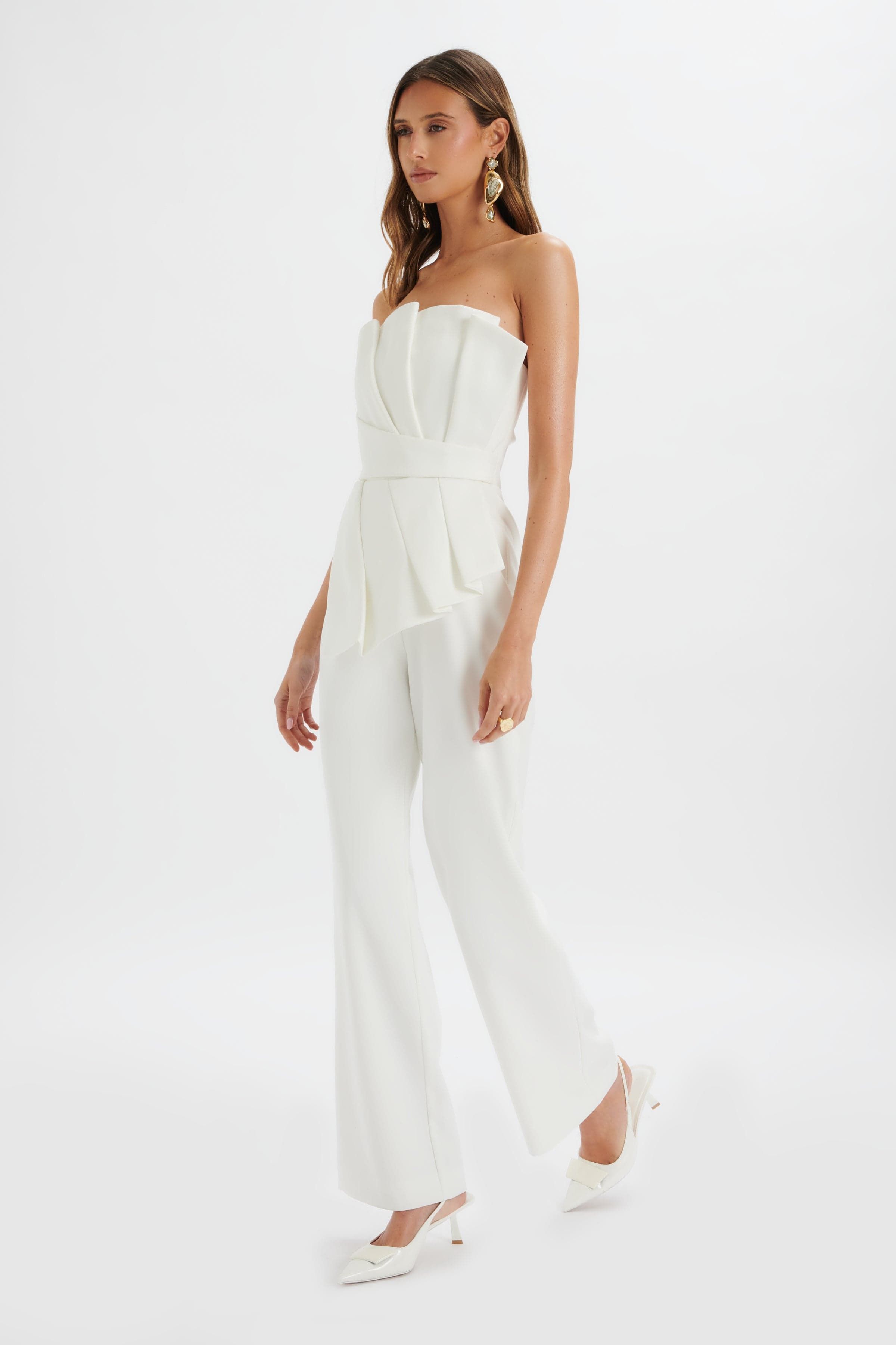 <p><strong>$128.00</strong></p><p><a href="https://lavishalice.com/products/asymmetric-pleated-frill-straight-leg-jumpsuit-in-white">Shop Now</a></p><p>We're obsessed with this white jumpsuit from Lavish Alice. Perfect for a city wedding, the strapless bandeau style features silky draped fabric, pleated detailing and frills. Add oversized earrings and you've got yourself a chic, contemporary bridal look.</p>