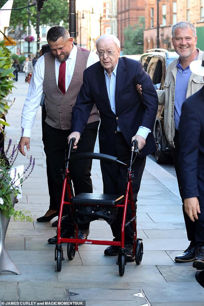sir michael caine, 91, pushes a walker as he's joined by wife shakira, 77, for a night out at the ivy