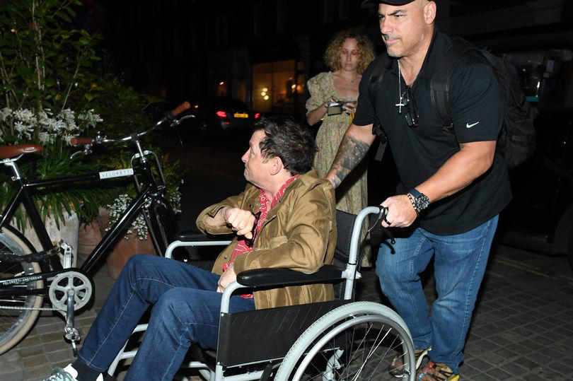 michael j fox flashes a peace sign from wheelchair in rare outing amid parkinson's battle