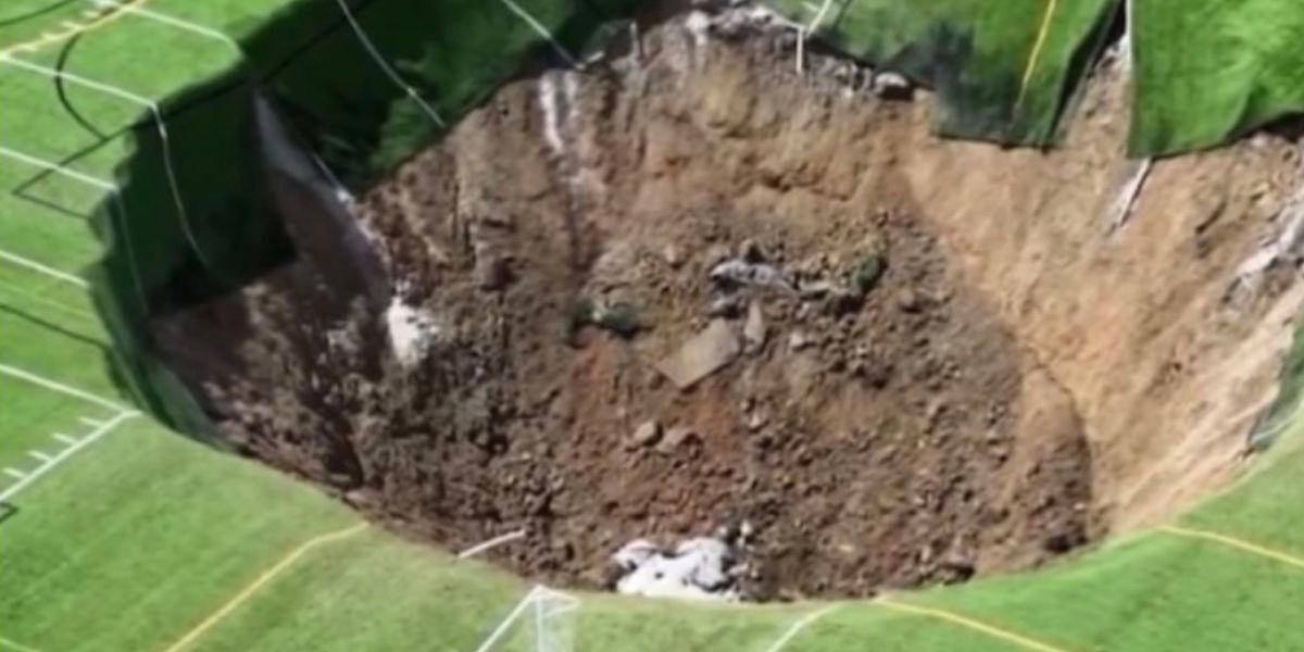 viral video viser øyeblikket da et gigantisk hull åpner seg midt på en fotballbane