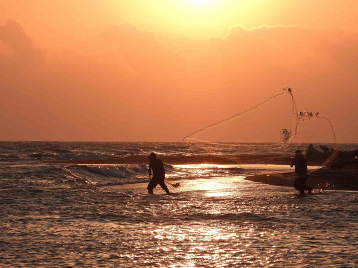 balıkçıların gün batımında balık mesaisi