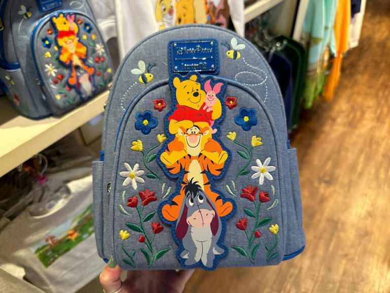 A new Winnie the Pooh Loungefly mini backpack features Pooh bear, Piglet, Tigger, and Eeyore. The backpack is available at Hundred Acre Goods in Magic Kingdom. Winnie the Pooh Loungefly Backpack – $88 The backpack is made of blue denim and pleather. A pleather patch of the four friends sitting on each other’s shoulders is ... Read more