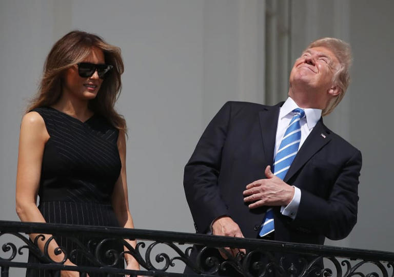U.S. President Donald Trump looks up toward the Solar Eclipse while joined by his wife first lady Melania Trump on the Truman Balcony at the White House on August 21, 2017 in Washington, DC. (Photo by Mark Wilson/Getty Images)