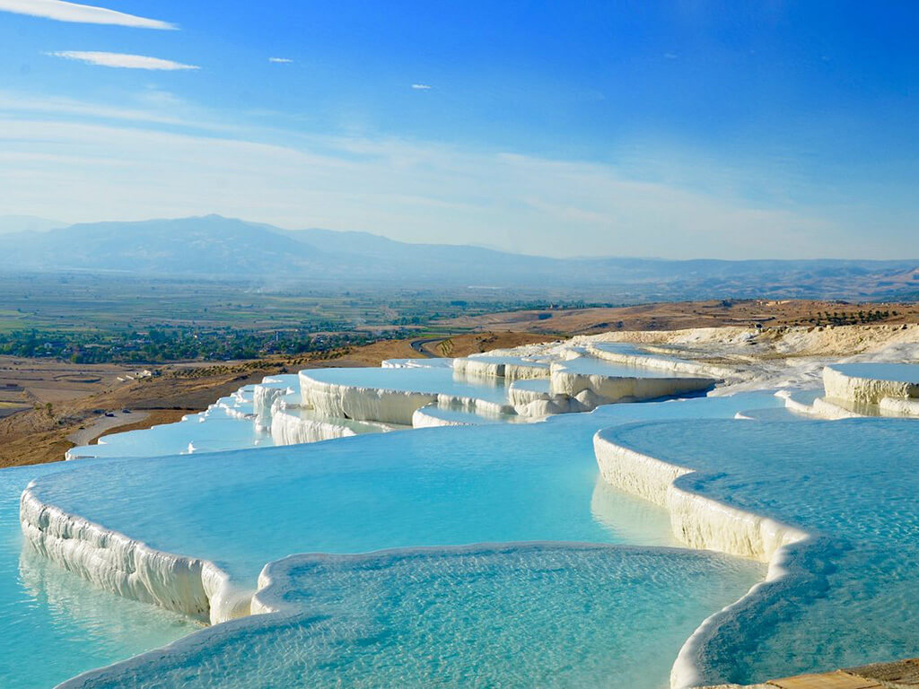 <p>Welcome to Pamukkale, also known as the “cotton castle” in English. Nestled in the southwest region of Turkey, this natural wonder is a sight to behold. Its name comes from the series of 17 cascading pools, formed over centuries by calcium deposits hardening into limestone, that create an otherworldly landscape. Perched high above the city of Denizli, Pamukkale has long been a sanctuary for those seeking tranquility and healing. Visitors flock to its rejuvenating waters to soak in the restorative benefits and marvel at the breathtaking scenery. With plenty of budget-friendly accommodations nearby, including guesthouses and hostels, it’s easy to plan a visit without breaking the bank. And with a day pass priced at just about $5, this enchanting destination offers an affordable escape for travelers of all budgets.</p>