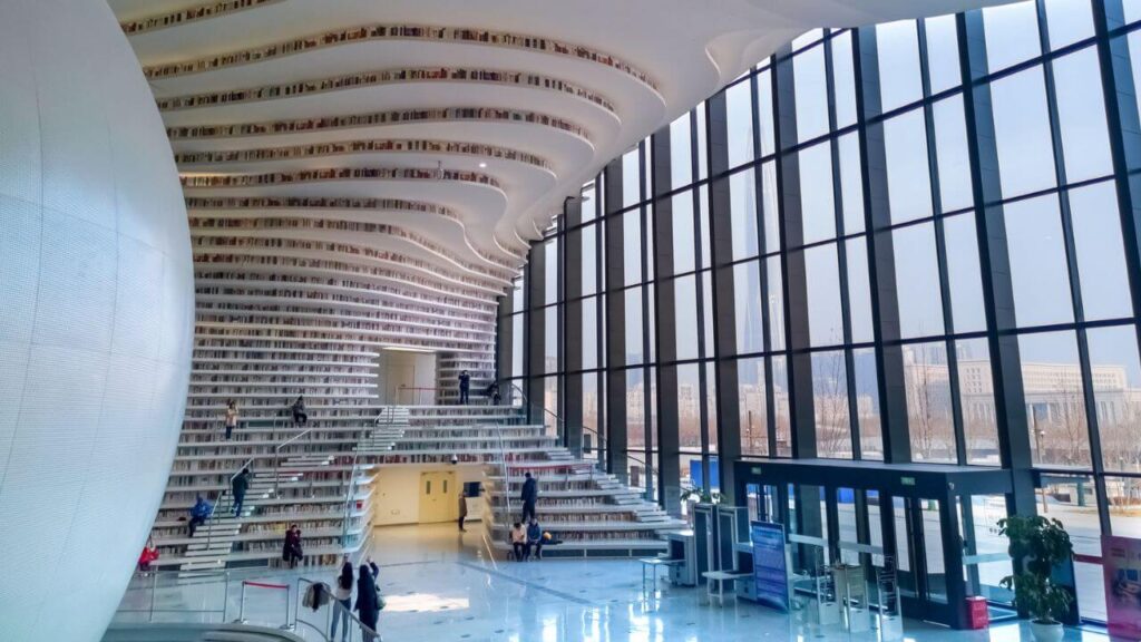 <p>Another one of the most uniquely designed libraries in the world is found in China. The Tianjin Binhai Library, also called “The Eye,” is both futuristic and sleek with its cascading bookshelves. It also has a luminous spherical auditorium at the center. </p><p>The clever design of terracing the shelves from floor to ceiling makes wise use of space. This way, the steps function as shelves and louvres that library-goers can use. </p>