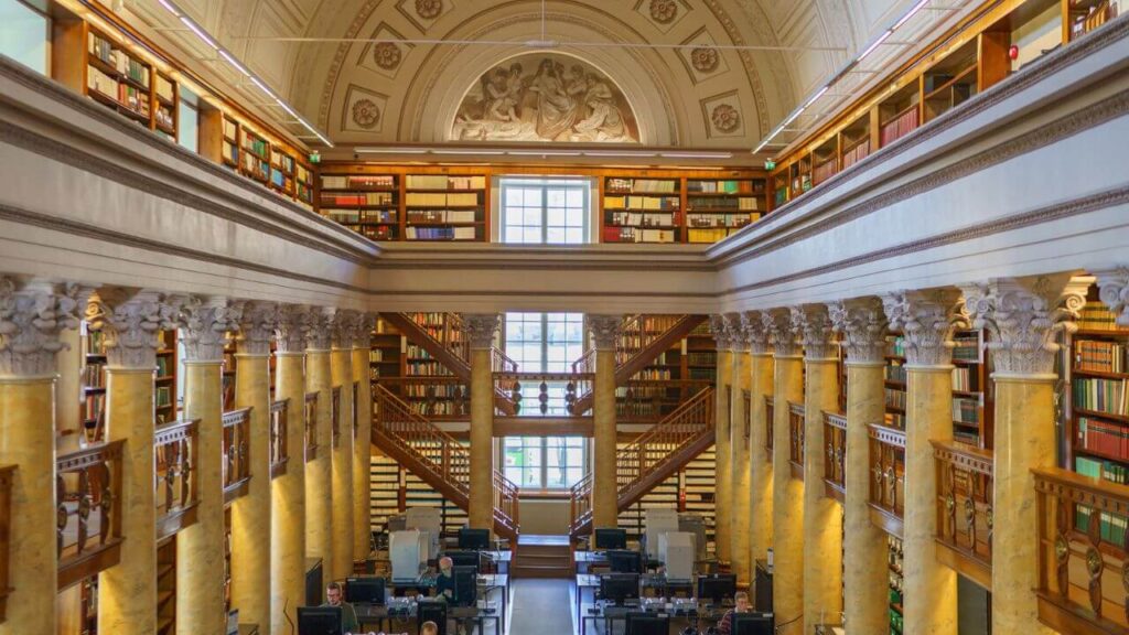 <p>The National Library of Finland is one of the most meticulously planned libraries in the world. From its location to the facade, columns, and layout, everything seems to be a tribute to Classicism and 18th-century architecture.</p><p>One of the most prominent structures in the library is the Cupola Hall, which looks grand with its dome ceiling and frescoes. Another is the Rotunda annex, built in 1906 but which shares the same artistic touch. The library’s interior differs from its simple or minimalist exterior.</p>