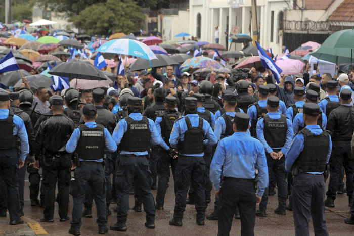 opositores marchan bajo la lluvia en honduras contra el gobierno y el foro de são paulo