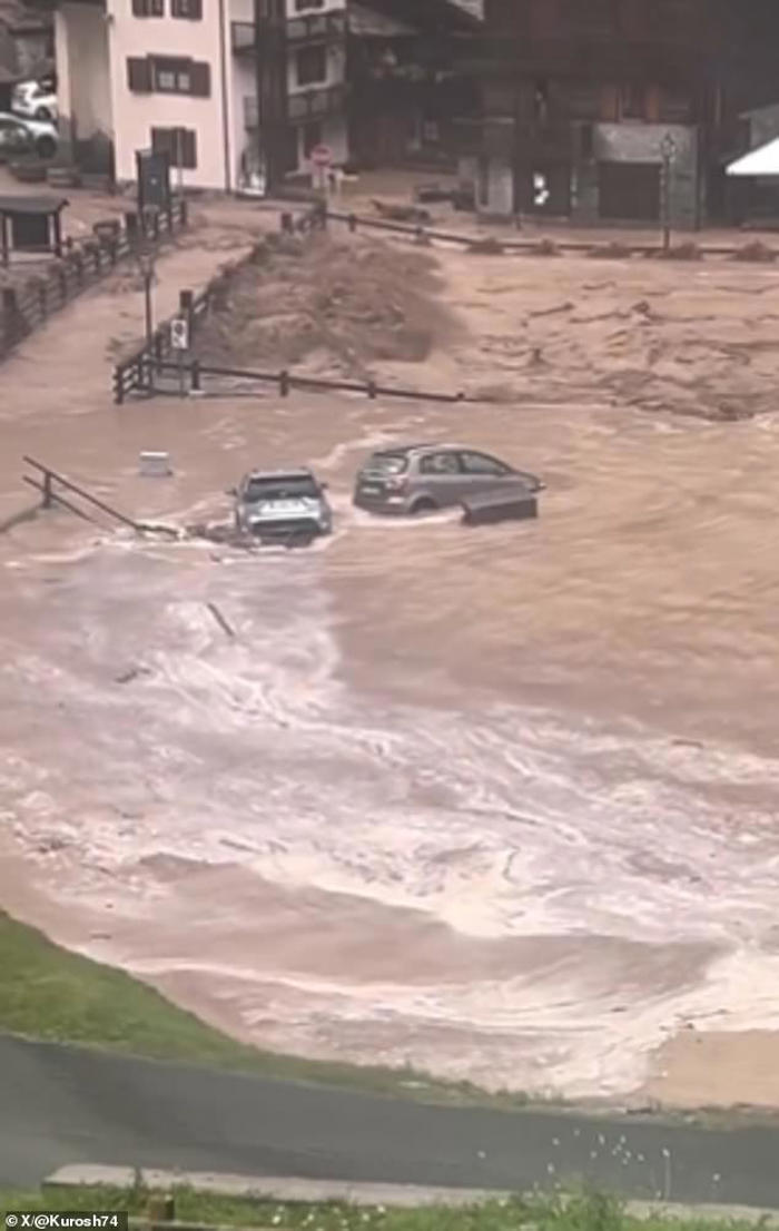 cars are washed down the road as huge floods hit italy and switzerland