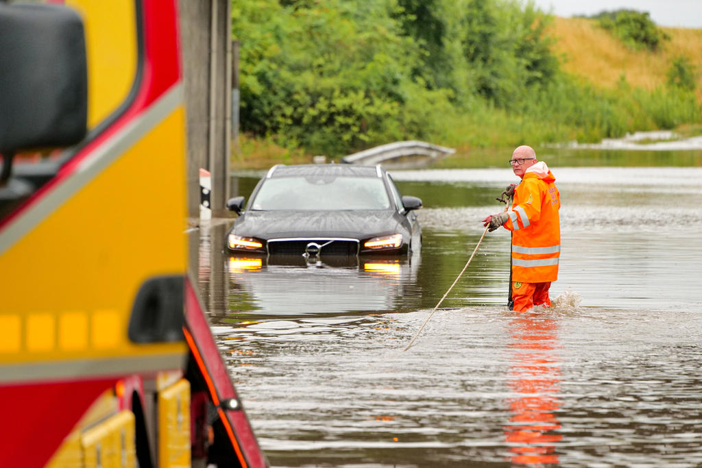 bilar fast i vattenmassorna efter skyfall