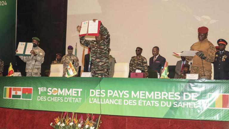 Le chef du gouvernement militaire du Niger, le général Abdourahamane Tiani (au centre), le colonel malien Assimi Goïta (à gauche) et le capitaine burkinabè Ibrahim Traoré (à droite) montrant les documents de la Confédération des États du Sahel (AES) qu'ils ont signés lors de leur premier sommet, à Niamey le 6 juillet 2024.