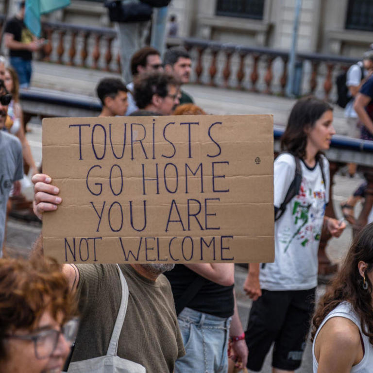 An anti-tourism placard is seen during the demonstration