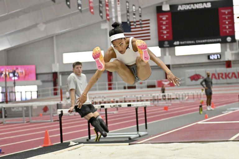 FILE - Olympic long jumper Tara Davis-Woodhall makes a practice jump at the Randal Tyson Track Center, Thursday Jan. 18, 2024, in Fayetteville, Ark. (AP Photo/Michael Woods)