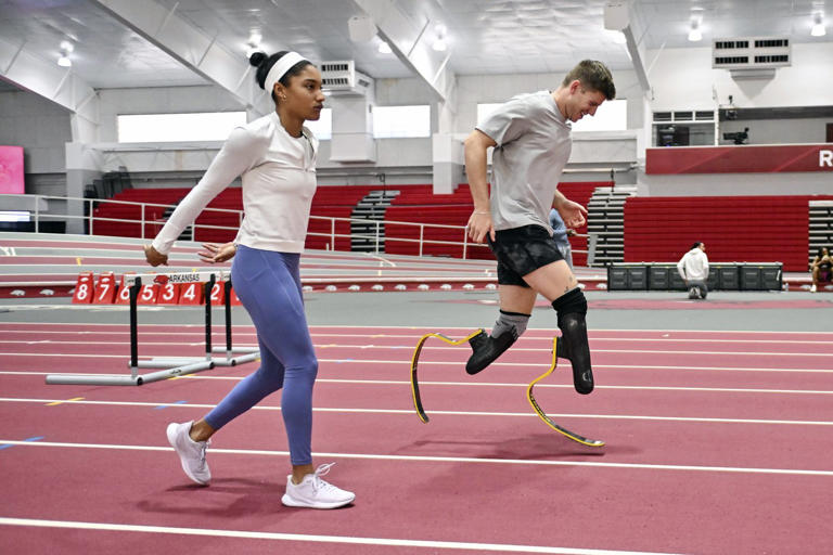 FILE - Olympic long jumper Tara Davis-Woodhall, left, works out with her husband, Paralympian sprinter Hunter Woodhall, at the Randal Tyson Track Center, Thursday Jan. 18, 2024, in Fayetteville, Ark. (AP Photo/Michael Woods)