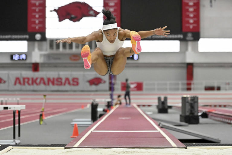 FILE - Olympic long jumper Tara Davis-Woodhall makes a practice jump at the Randal Tyson Track Center, Thursday Jan. 18, 2024, in Fayetteville, Ark. The 25-year-old former world youth champion and reigning world indoor champion became a “name” in high school when she broke a 24-year-old record held by none other than Marion Jones.(AP Photo/Michael Woods, File)