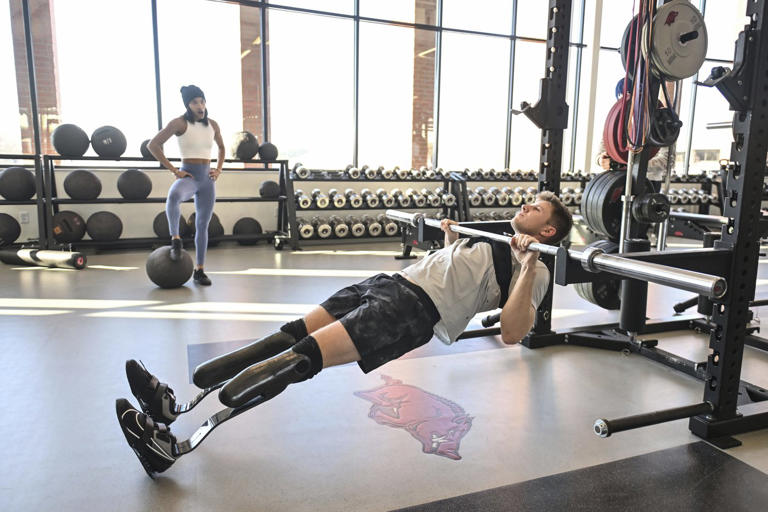 FILE - Olympic long jumper Tara Davis-Woodhall, left, works out with her husband, Paralympian sprinter Hunter Woodhall, at the Frank O'Mara Track and Field High Performance Center Thursday Jan. 18, 2024, in Fayetteville, Ark. (AP Photo/Michael Woods, File)