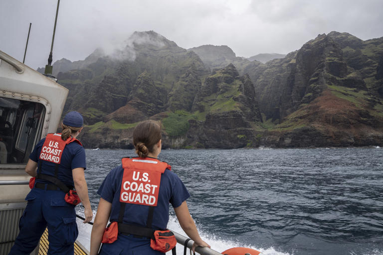 In this photo provided by the U.S. Coast Guard, coast guardsmen participate in a search after a helicopter crash near Na Pali Coast, Kauai, Hawaii. The tour company aircraft went down off the Hawaiian island of Kauai, police said, in the latest in a series of crashes to plague the industry in recent years. (Ty Robertson/USCG via AP)