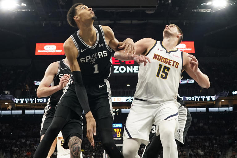 Apr 12, 2024; San Antonio, Texas, USA; Denver Nuggets center Nikola Jokic (15) and San Antonio Spurs forward Victor Wembanyama (1) box out for a rebound during the second half at Frost Bank Center. Scott Wachter-USA TODAY Sports