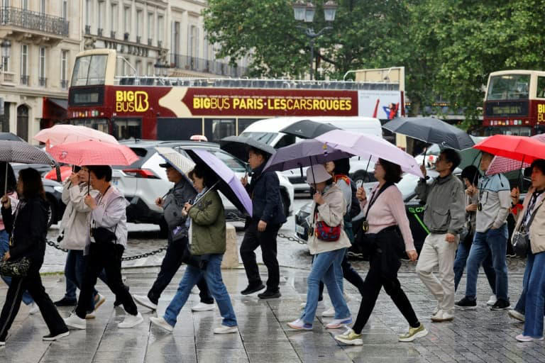 Des touristes sous la pluie à Paris, le 31 mai 2024