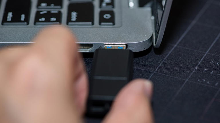 Person inserting USB into a port