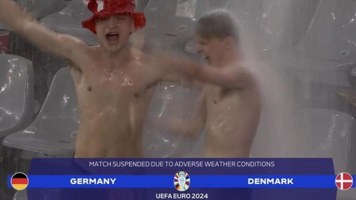 cae un diluvio, se suspende el partido por una tormenta eléctrica... y dos fans de dinamarca aprovechan para bailar bajo la lluvia