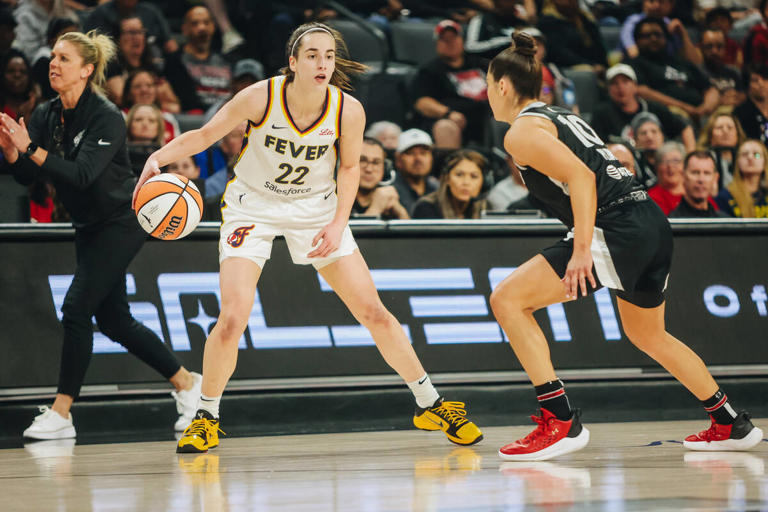 Indiana Fever guard Caitlin Clark (22) dribbles the ball as Aces guard Kelsey Plum (10) guards her during a game between the Aces and Indiana Fever at Michelob Ultra Arena on Saturday, May 25, 2024, in Las Vegas.