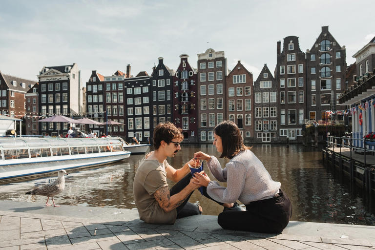 young couple eating fries in the center of amsterdam