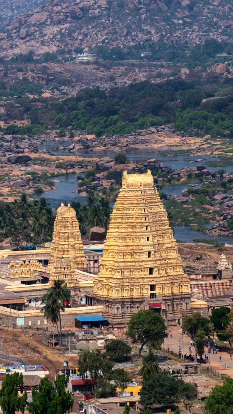 Explore the historical ruins of Hampi after a scenic drive through rural Karnataka, passing by picturesque landscapes and ancient temples.