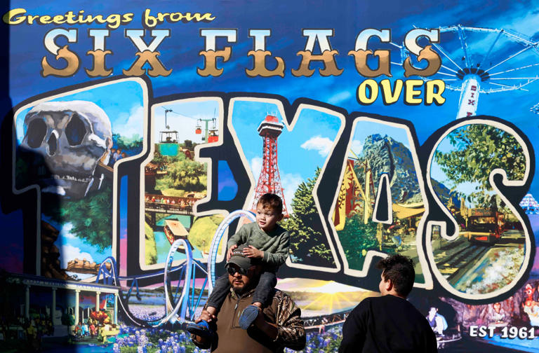 Patrons walk past a mural at Six Flags Over Texas on Saturday, March 9, 2024, in Arlington, Texas.