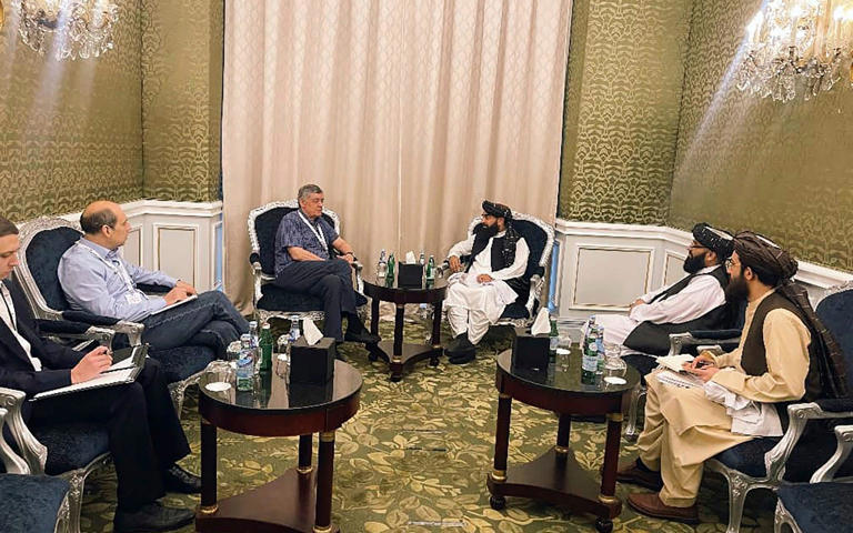 Zabihullah Mujahid, the Taliban's chief spokesman, speaks with the Russian presidential envoy Zamir Kabulov during a meeting in Qatar last month - Taliban Spokesman Office via AP