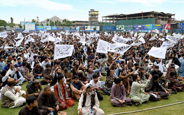 Cricket fans in Kabul wave Taliban flags as they watch their country's team at the Twenty20 World Cup. Putin has praised the regime for bringing calm and stability to Afghanistan - Wakil Kohsar/AFP via GettyImages