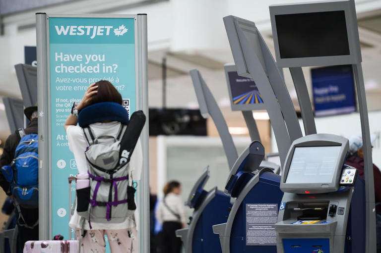 Passengers are seen in the WestJet check-in area at Pearson International Airport, in Toronto on June 29, 2024. THE CANADIAN PRESS/Christopher Katsarov