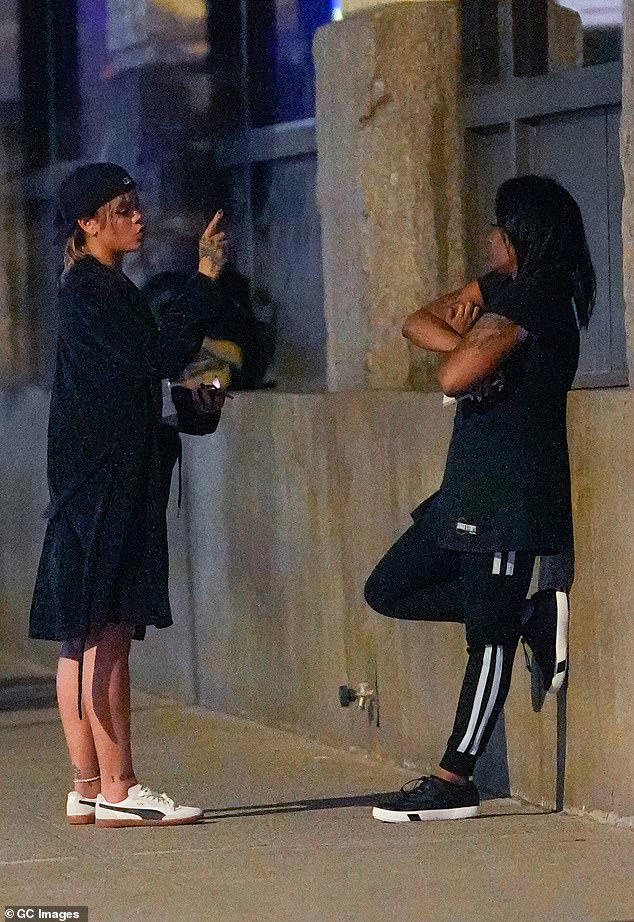 Rhianna stopped for a brief chat with a pal, who was seen leaning on a wall as they talked