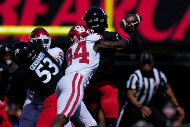 Oklahoma Sooners defensive lineman Adepoju Adebawore (34) knocks the ball loose as Cincinnati Bearcats quarterback Emory Jones (5) throws in the third quarter of the NCAA Big 12 football game between the Cincinnati Bearcats and the Oklahoma Sooners at Nippert Stadium in Cincinnati on Saturday, Sept. 23, 2023. The Bearcats lost their first Big 12 football game, 20-6, to the Sooners before a sellout crowd. Sam Greene/The Enquirer / USA TODAY NETWORK