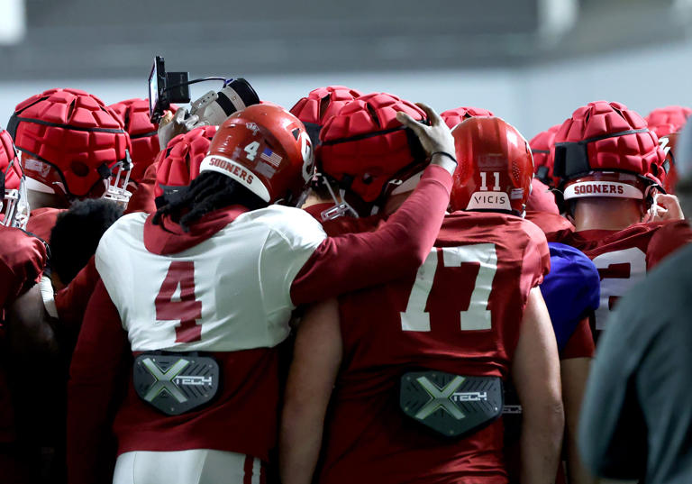 Oklahoma's Justin Harrington (4) and Heath Ozaeta (77) join a huddle during the University of Oklahoma (OU) spring football practice at the Everest Training Center in Norman, Okla., Wednesday, March 27, 2024. SARAH PHIPPS/THE OKLAHOMAN / USA TODAY NETWORK