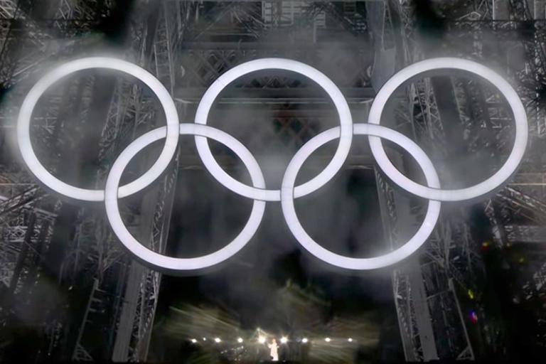 Celine Dion singing on the first stage of the Eiffel Tower underneath the Olympic rings on Friday, July 26. NBC