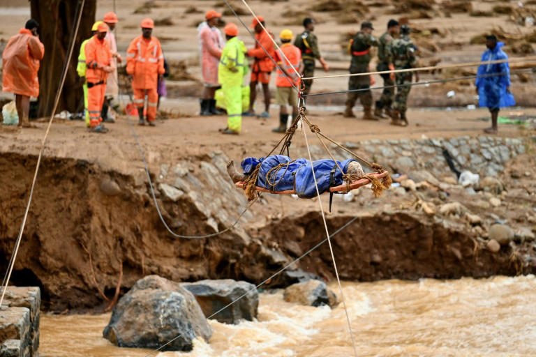 El personal de socorro levanta un cuerpo sobre las aguas de las inundaciones después de que los deslizamientos de tierra afectaran aldeas en el estado indio de Kerala, matando al menos a 160 personas