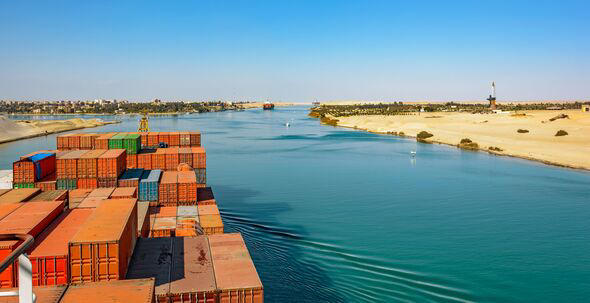 Industrial container ship passing through Suez Canal with ship's convoy, view on the bow from the captain bridge.