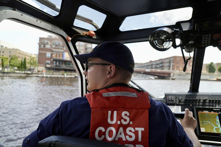 Boson's mate second class Tyler Boon navigates a U.S. Coast Guard small response boat down the Milwaukee River toward the RNC security zone on Wednesday, July 17, 2024 in Milwaukee, Wis. (AP Photo/Mark Vancleave)