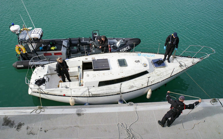 Officials moor the yacht on Saturday, after towing it to Dover harbour