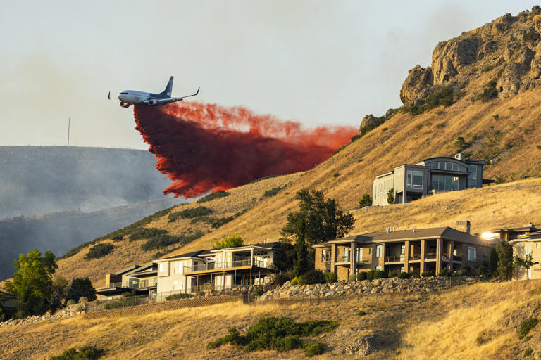 A plane drops fire retardant as the Sandhurst Fire burns above Ensign Peak north of Salt Lake City on Saturday, July 20, 2024. (Isaac Hale/The Deseret News via AP)