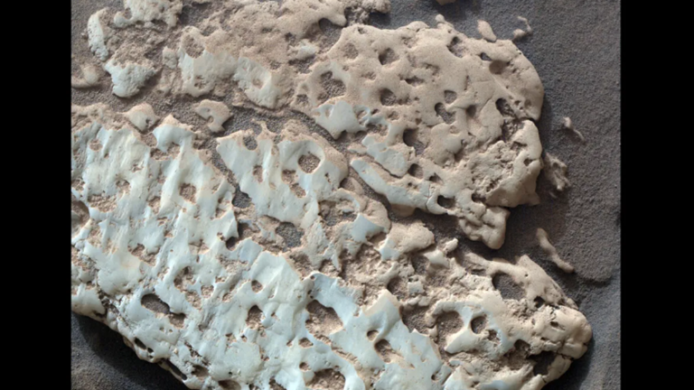 Curiosity maakte een close-up van een witte steen, gelijkaardig aan degene die onlangs openbarstte. Er ligt in de buurt een heel veld.