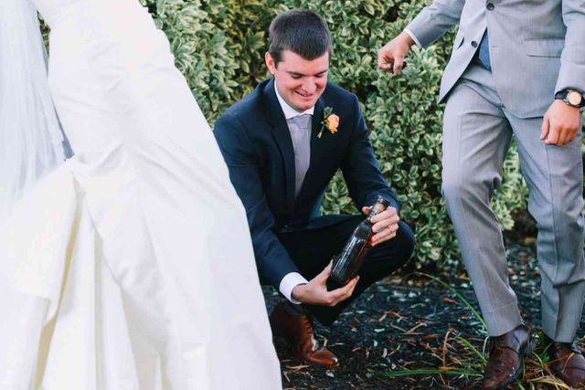 Bride and groom digging up bottle of bourbon