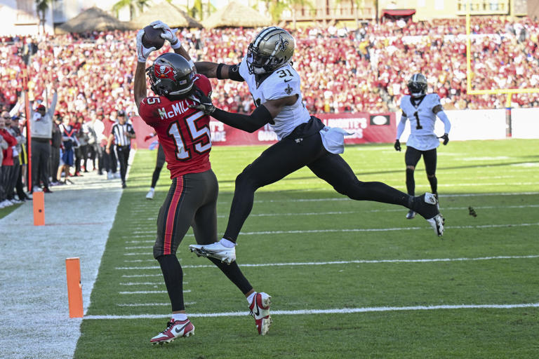 Tampa Bay Buccaneers wide receiver Jalen McMillan (15) pulls in a touchdown reception against New Orleans Saints safety Jordan Howden (31) during the second half of an NFL football game Sunday, Jan. 5, 2025, in Tampa, Fla. (AP Photo/Jason Behnken)